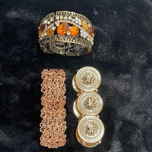 Three bracelets rose gold , yellow gold w/rhinestones, and bronze cuff w/stones